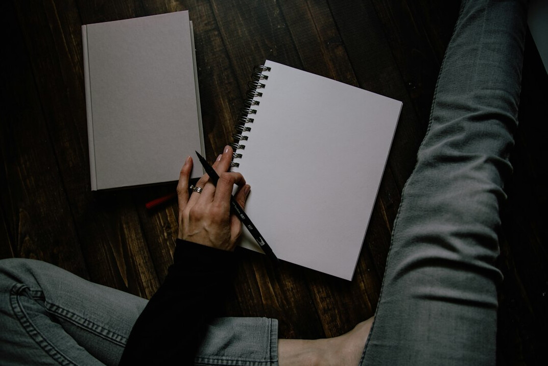 person writing in notebook